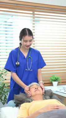 Pratisyen, yaşlı bir kadına Reiki tedavisi uyguluyor. Alternatif tıp ve Reiki tekniği kavramı.