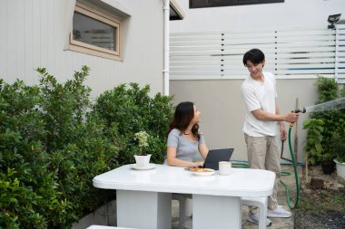 Neşeli Asyalı çift bahçede birlikte dinleniyor..