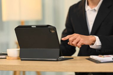 Resmi giyimde vurulan işadamı dijital tablet üzerindeki görevleri yönetiyor.