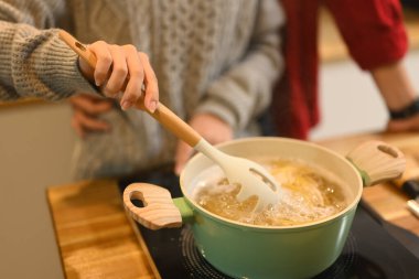 Şenlik sezonunda, sıcak bir mutfakta birlikte makarna pişiren çiftin yakın çekimi..