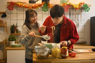 Mutlu çift dekore edilmiş bir mutfakta birlikte yemek hazırlıyor..