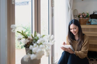 Büyüleyici genç bir kadın defterine düşüncelerini yazıyor..