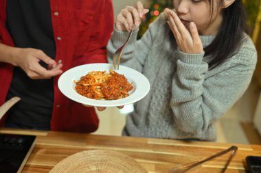 Genç çift Noel yemeğinde lezzetli bir tabak spagetti yiyor..