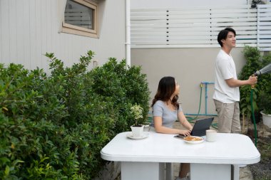 Mutlu Asyalı çiftler, arka bahçede keyifli bir gün geçiriyorlar..