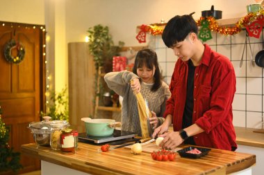 Mutlu genç çift tatillerde lezzetli bir ev yemeği için malzemeleri hazırlıyor..