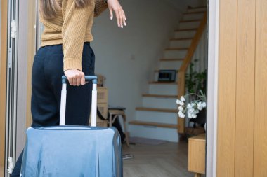 Genç bir kadın bir bavul taşıyor ve yeni evine giriyor...