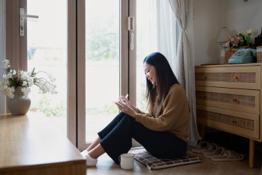 Pencerenin kenarında oturan huzurlu kadın defterine düşüncelerini yazıyor..