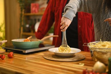 Genç çift, evlerinin mutfağında Noel yemeği için malzeme hazırlıyor..