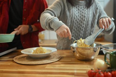 Genç bir kadın tatil sezonunda mutfakta ev yapımı makarna hazırlıyor..