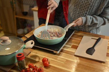 Genç bir kadın tatil sezonunda mutfakta ev yapımı makarna hazırlıyor..