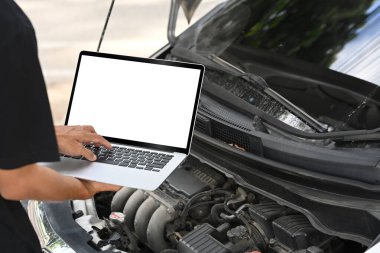 Aracın motor sorunlarını teşhis etmek için dizüstü bilgisayar kullanan tamirciyi kapat.