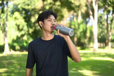 Erkek koşucunun doğada koşmaya ve su içmeye ara verdiği bir sahne..