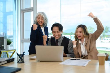 Bir grup iş adamı ofiste başarılı projelerini kutluyorlar..