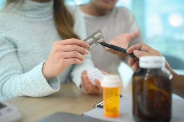 Muayene sırasında hastaya ilaç dozajını açıklayan doktoru kapat..