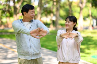 Mutlu baba-kız sabah antrenmanı için sakin bir parkta ısınıyor..