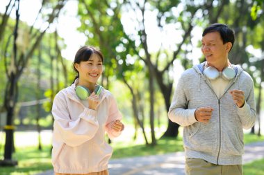 Neşeli baba ve kızı güneşli bir parkta koşuyor. Sağlık ve aile faaliyeti kavramı.