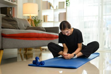 Genç Asyalı kadın evde egzersiz yapıyor, kelebek pozu veriyor..