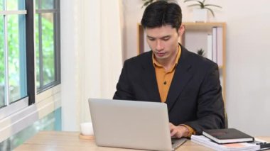 Formalite icabı Asyalı işadamı dizüstü bilgisayarındaki işleri yönetiyor..