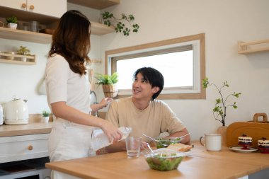 Sıcak bir mutfakta kahvaltı ve sohbet eden bir çift..