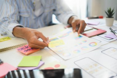 Uygulama tasarımı üzerinde çalışan UX tasarımcısı detaylı çizimler tüm masaya yayıldı.