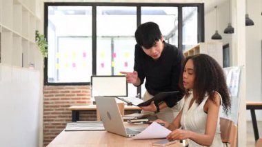 Gülümseyen şirket çalışanları yeni fikirleri paylaşıyor ve modern ofiste pazarlama projeleri üzerinde çalışıyorlar..