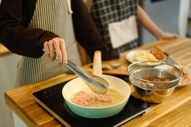 Genç eşcinsel çift sıcak mutfakta lezzetli bir kahvaltı hazırlıyor..