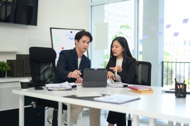 Profesyonel işadamları dijital tablet üzerindeki belge ve verileri inceliyor.