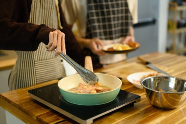 Genç eşcinsel çift sıcak mutfakta kahvaltı hazırlıyor..