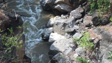 Etrafı yemyeşil sularla çevrili akarsu nehrinin üstünde ve huzurlu bir doğal kaçış sunan büyük kayalar..