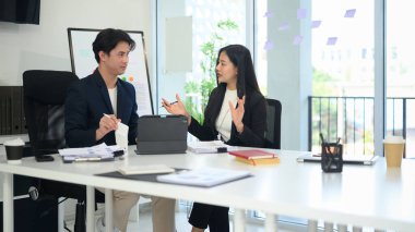 İş arkadaşları fikir alışverişinde bulunuyor ve çağdaş çalışma alanında bir proje üzerinde işbirliği yapıyorlar.