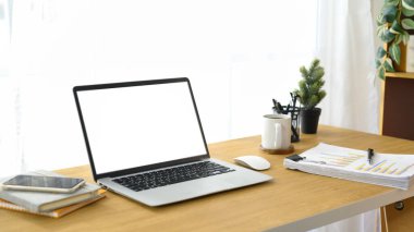 Bilgisayarı, akıllı telefonu ve ahşap masasında iş evrakları olan modern çalışma alanı..