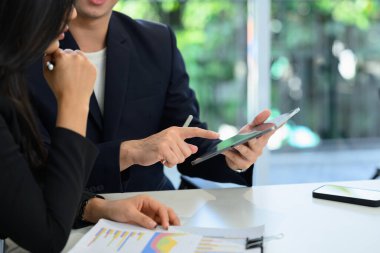 İki şirket iş arkadaşı dijital tablet istatistiklerini tartışıyor ve analiz ediyorlar.