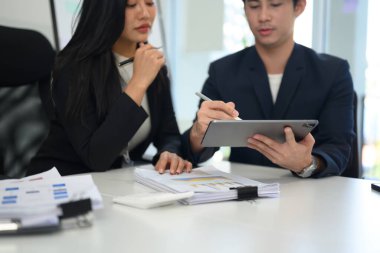 İki şirket iş arkadaşı dijital tablet istatistiklerini tartışıyor ve analiz ediyorlar.