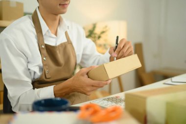 Genç girişimci etiketleme paketi sevkiyata hazırlanıyor. E-ticaret iş konsepti.