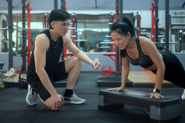 İtme egzersizi sırasında müvekkiline yardımcı olan kişisel antrenör..