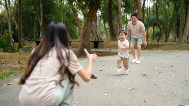 Sevimli küçük çocuk heyecanla annesine doğru koşuyor. Ebeveynlik, aile ve açık hava eğlence konsepti..