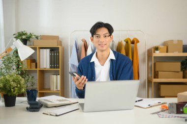 Kendine güvenen küçük işletme sahibi akıllı telefonundaki siparişleri ve müşteri etkileşimlerini yönetiyor..