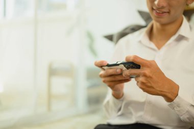 Gülümseyen adamın evdeki mobil oyunlardan zevk aldığı sahneler..