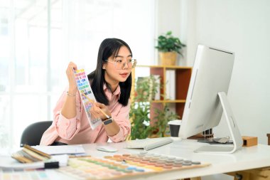 Müşterisiyle görüntülü konuşma sırasında renk seçenekleri sunan iç mimar.