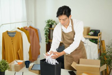 Küçük işletme sahibi teslimat için bir paket hazırlıyor..