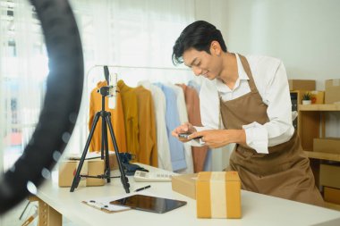 Küçük işletme sahibi bir internet mağazası için fotoğraf çekmek için akıllı telefon kullanıyor..