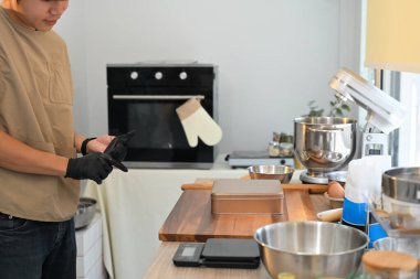 Küçük işletme girişimcisi modern bir mutfakta kurabiye pişirmeye hazırlanıyor..