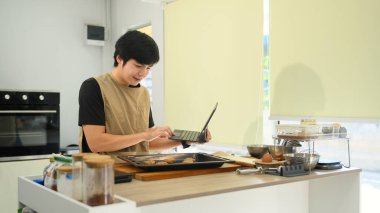 Önlüklü küçük işletme sahibi dijital tabletinden online siparişler alıyor..