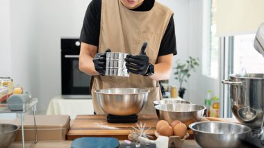 Erkek fırıncı, çikolata parçacıklı kurabiye hamuru için mutfak tezgahında un seçiyor..