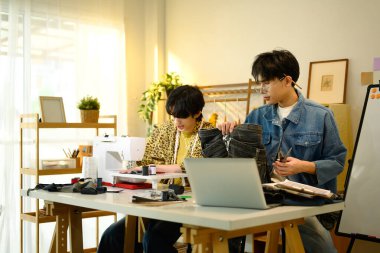 Genç moda tasarımcıları bir stüdyoda yeni bir proje üzerinde çalışıyorlar..