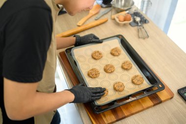 Pişirmeden önce bir tepsi çikolatalı kurabiye hamuru hazırlıyor..