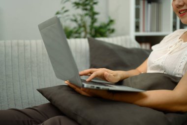 Gülümseyen orta yaşlı kadının dijital tabletini kullanarak içeriği gözlemek ya da izlemek için yakın plan.