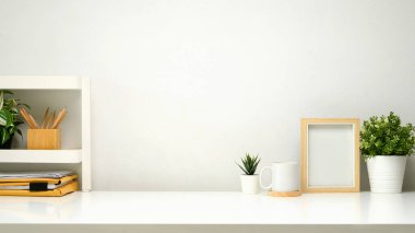 Küçük raflı minimalist çalışma alanı, resim çerçevesi, kahve ve malzeme..
