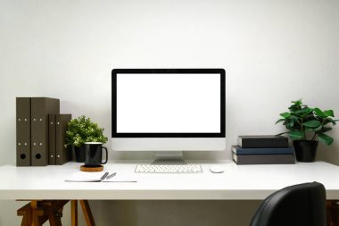 Masaüstü bilgisayarı, ofis malzemeleri ve beyaz masadaki saksı bitkileri..