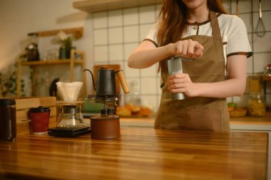 Mutfak tezgahında el değirmeniyle taze kahve çekirdeklerini öğütürken yakın çekim..